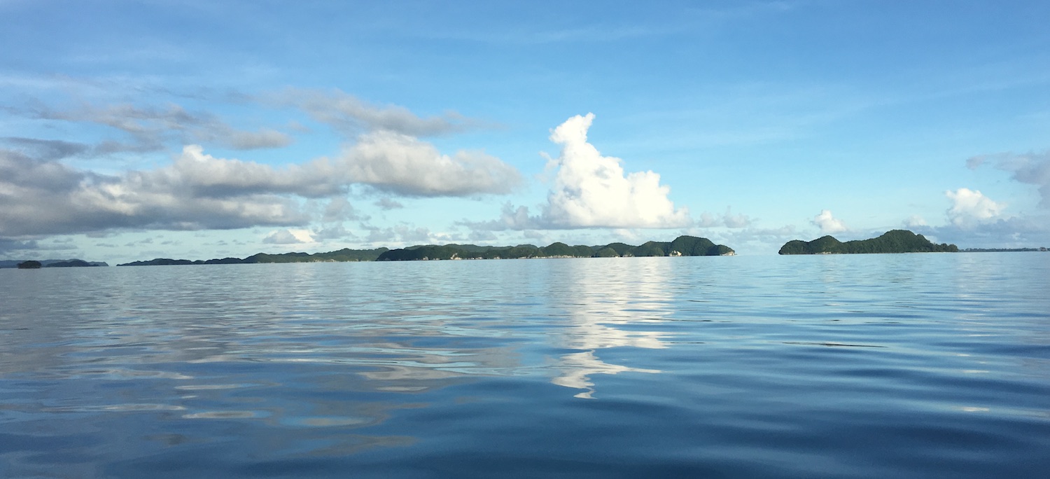Rock Islands in Palau with clouds reflected in the calm water