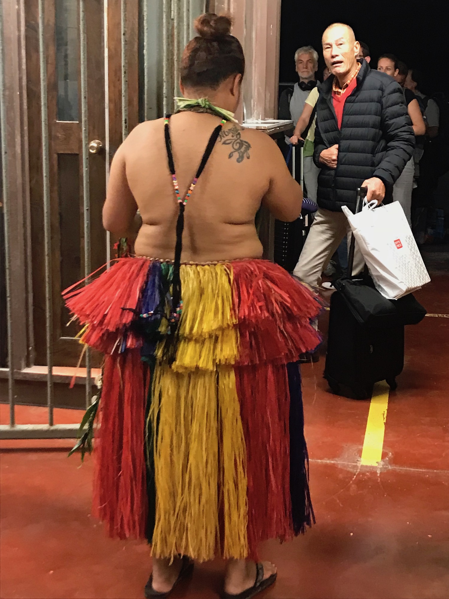 Woman in grass skirt greets visitors at Yap airport