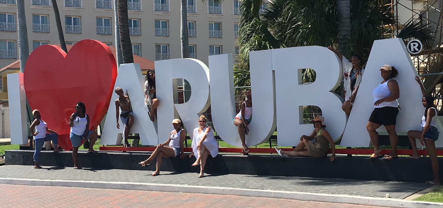 Bachelorettes posing at a massive I Heart Aruba sign